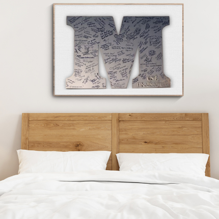 Bedroom with wooden headboard, white bedding, and framed artwork on the wall.