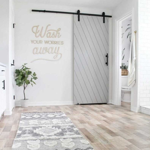 Bathroom with a white sliding door and motivational quote on a wall.